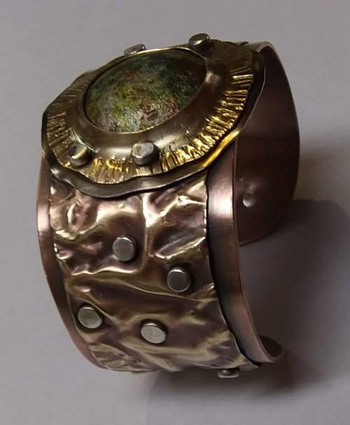 Judy Larson's Fold Formed Cuff With Faux Roman Glass or Coin Cabochon - , Metalwork, Cutting, Cutting Tool, Cutters, Dapping, Dapping Jewelry, Filing, Finishing, Forging, Forging Jewelry, Jewelry Forging, How To Punch Holes, Hole Punching, Punch A Hole, Oxidizing Wire, Oxidizing, Antiquing Wire, Antiquing, Riveting, Riveting Techniques, Wire Rivets, Sawing, Saw, Wire Saw, Texturing, Drilling, Drill, Fold Formed Faux Roman Glass Cuff